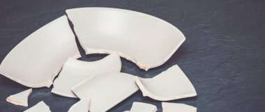 Mutfağın zemininde kırık tabaklar ya da kırık su bardakları. Mutfaktaki kaza kavramı, evin içindeki beden ve çocuklar için tehlikelidir..