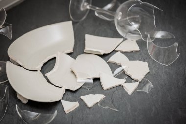 Mutfağın zemininde kırık tabaklar ya da kırık su bardakları. Mutfaktaki kaza kavramı, evin içindeki beden ve çocuklar için tehlikelidir..