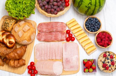 Sabah kahvaltı masada kruvasan ekmeği, kruvasan gevreği, pastırma, jambon, peynir, marul, fasulye, mısır gevreği, sağlıklı kahvaltı için meyve ve fotokopi alanı ile servis edilir.