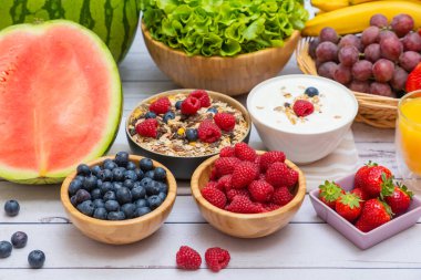 Toplu meyveler karışık ve sebzeler salata kasesi, fındık kasesi, çilek, muz ve ananas, portakal suyu, C vitamini..