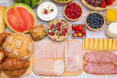 Sabah kahvaltısı sebze, kruvasan ekmeği, jambon, peynir, marul, fasulye, mısır gevreği ve meyveli olsun.