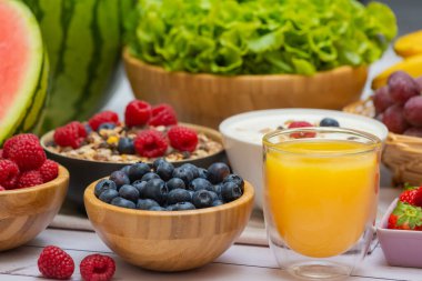 Toplu meyveler karışık ve sebzeler salata kasesi, fındık kasesi, çilek, muz ve ananas, portakal suyu, C vitamini..