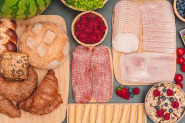 Sabah kahvaltı masada kruvasan ekmeği, kruvasan gevreği, pastırma, jambon, peynir, marul, fasulye, mısır gevreği, sağlıklı kahvaltı için meyve ve fotokopi alanı ile servis edilir.