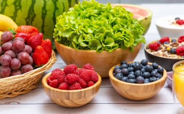 Toplu meyveler karışık ve sebzeler salata kasesi, fındık kasesi, çilek, muz ve ananas, portakal suyu, C vitamini..