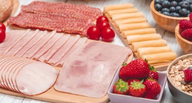 Sabah kahvaltı masada kruvasan ekmeği, kruvasan gevreği, pastırma, jambon, peynir, marul, fasulye, mısır gevreği, sağlıklı kahvaltı için meyve ve fotokopi alanı ile servis edilir.