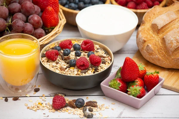 Kahvaltıda yanında tereyağlı kruvasan, mısır gevreği, fincanda süt, çilek, ahududu, kivi, kahvaltı masasında taze portakal suyu....