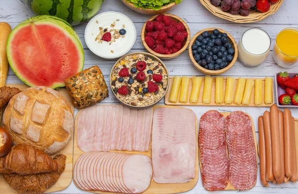 Sabah kahvaltısı sebze, kruvasan ekmeği, jambon, peynir, marul, fasulye, mısır gevreği ve meyveli olsun.