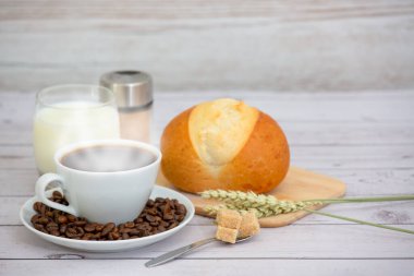 Sabah kahvaltısı, siyah kahve fincanı, ekmek, kruvasan ve ahşap masada meyve..