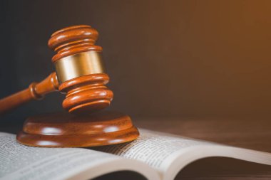 Tahta arka planda hukuk kitabı olan yaşlı tahta çekiç yargı ve adalet için kullanılır..