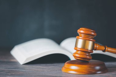Tahta arka planda hukuk kitabı olan yaşlı tahta çekiç yargı ve adalet için kullanılır..