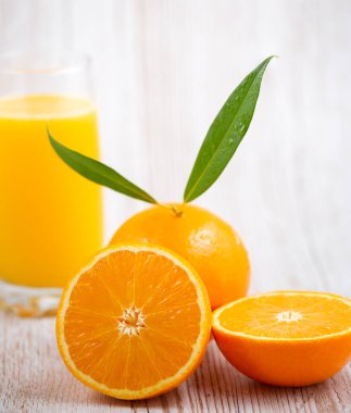 Ahşap arka planda doğal taze meyve portakalları, yarım kesilmiş portakal, portakal suyu, günlük sağlık için C vitamini.