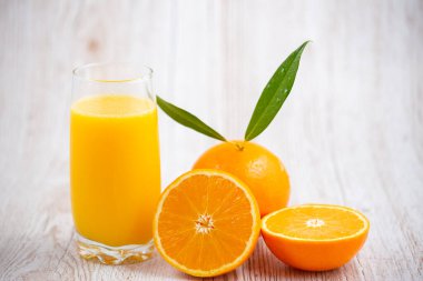 Ahşap arka planda doğal taze meyve portakalları, yarım kesilmiş portakal, portakal suyu, günlük sağlık için C vitamini.