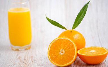 Ahşap arka planda doğal taze meyve portakalları, yarım kesilmiş portakal, portakal suyu, günlük sağlık için C vitamini.