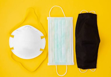 Doktor Maskesi ve Kumaş Maskesi, Koronavirüs mikrobu takmak için N95 veya sarı arka plandaki doktor ve hastaneler için CV19..