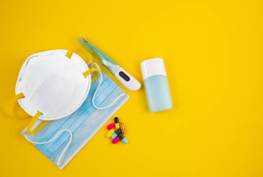 Doktor Maske, mikrop koruması için N95 maskesi Coronavirus veya Coperid 19 ve jel alkolü ya da el temizleme için el dezenfektanı şişesi, sarı arka plandaki doktor hastaneleri için ateş monitörü..
