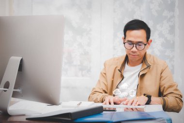 Günlük kıyafet giymiş Asyalı bir adam evdeki mutfak masasındaki müşteriyle internet üzerinden iletişim kuruyor. konsept çalışması.