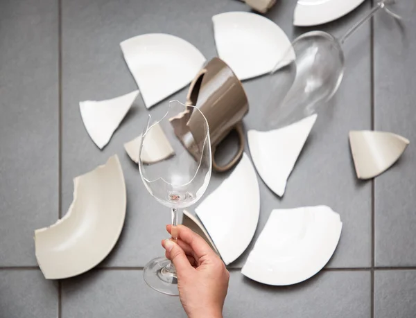 Broken Plate or broken water glass and dishes on the floor in the kitchen room The concept of accidents in the kitchen is dangerous for the body and young children inside the house.