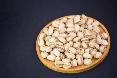 Fıstık ezmesi, ahşap tabağa tuz karıştırılmış Protein yiyeceği ve siyah arka planda diyet yemeği..