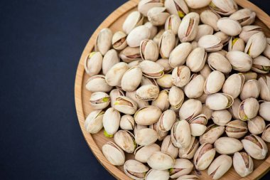 Fıstık ezmesi, ahşap tabağa tuz karıştırılmış Protein yiyeceği ve siyah arka planda diyet yemeği..