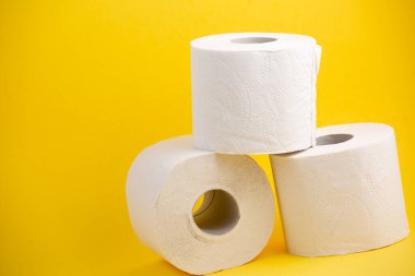 Banyolarda ya da mutfaklarda kullanılmak üzere büyük beyaz bir tuvalet kağıdı rulosu, sarı arka plandaki kirleri temizlemek için kullanılır.