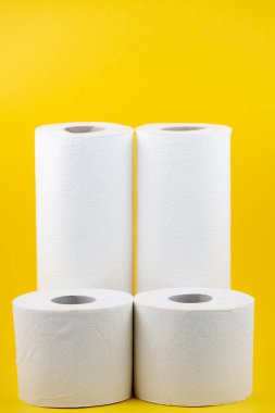 Banyolarda ya da mutfaklarda kullanılmak üzere büyük beyaz bir tuvalet kağıdı rulosu, sarı arka plandaki kirleri temizlemek için kullanılır.
