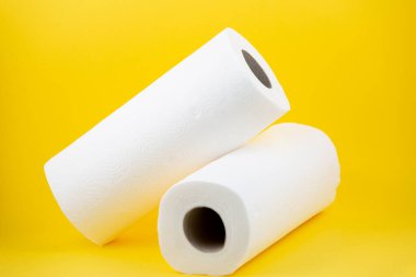 Banyolarda ya da mutfaklarda kullanılmak üzere büyük beyaz bir tuvalet kağıdı rulosu, sarı arka plandaki kirleri temizlemek için kullanılır.