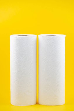 Banyolarda ya da mutfaklarda kullanılmak üzere büyük beyaz bir tuvalet kağıdı rulosu, sarı arka plandaki kirleri temizlemek için kullanılır.