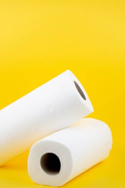 Banyolarda ya da mutfaklarda kullanılmak üzere büyük beyaz bir tuvalet kağıdı rulosu, sarı arka plandaki kirleri temizlemek için kullanılır.