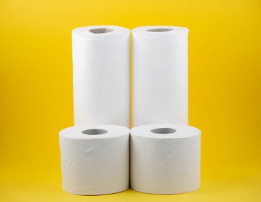 Banyolarda ya da mutfaklarda kullanılmak üzere büyük beyaz bir tuvalet kağıdı rulosu, sarı arka plandaki kirleri temizlemek için kullanılır.