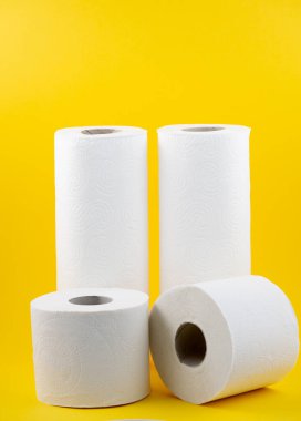 Banyolarda ya da mutfaklarda kullanılmak üzere büyük beyaz bir tuvalet kağıdı rulosu, sarı arka plandaki kirleri temizlemek için kullanılır.