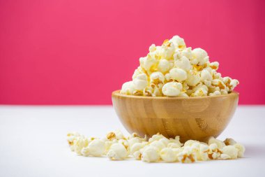 Ahşap masadaki ahşap kasede tereyağlı patlamış mısır, kavrulmuş mısır taneleri doğal tuzla karıştırılmış, sinemada aperatifler ya da parti.