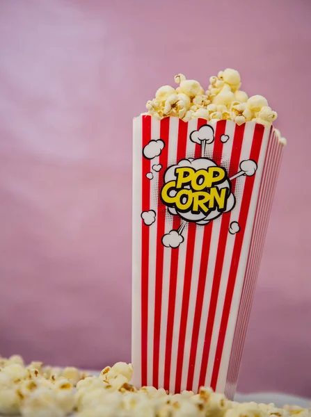 Buttered movie popcorn in a popcorn cup on white background