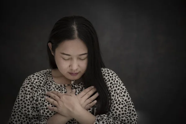 Asian face woman praying and worship to GOD Using hands to pray in religious beliefs and worship christian in the church or in general locations in  White and Black background