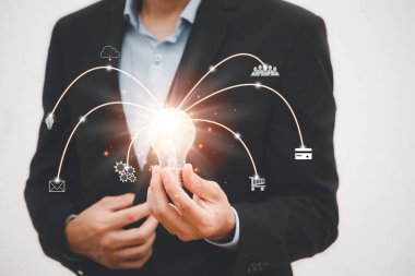 İş adamı, ampulü grafik ekranı, Teknoloji İşlem Sistemi İş Konseptinin Ekran Simgesi 'nde tutuyor.