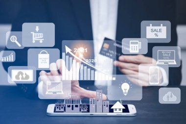 İş adamı grafik simgesini seçer ve bilgisayarla veya akıllı fonla modern bir kredi kartı kullanır. İnternet üzerinden alışveriş yapar ve sipariş alışverişini internetten satın alır..