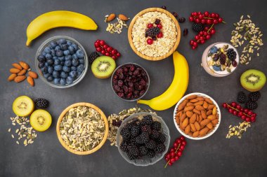 Ekmek, kepekli ve fındıklı grup meyveli kahvaltı, kirazlı yoğurt, muz, ahşap masada avokado. Sağlık ve Diyet Kahvaltısı konsepti