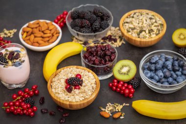 Fıstık ve tahıllı meyve ve kahvaltı, kirazlı yoğurt, muz, ahşap masada avokado. Sağlık ve Diyet Kahvaltısı konsepti