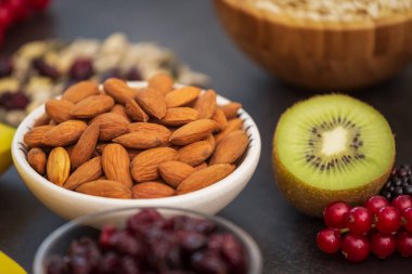 Fıstık ve tahıllı meyve ve kahvaltı, kirazlı yoğurt, muz, ahşap masada avokado. Sağlık ve Diyet Kahvaltısı konsepti