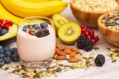 Fıstık ve tahıllı meyve ve kahvaltı, kirazlı yoğurt, muz, ahşap masada avokado. Sağlık ve Diyet Kahvaltısı konsepti