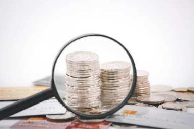 Kredi kartı ve büyüteç içeren madeni paralar finans ve bankacılık, tasarruf fikirleri ve yatırım bütçesi için beyaz arka planda, yaratıcı fikirler tasarruf konsepti para tasarrufu