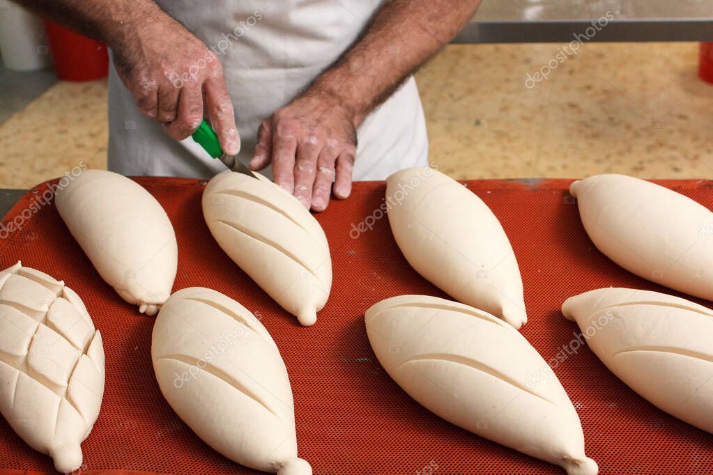 Cortar en el pan del pan ya fermentado antes de que entre en el horno 2022
