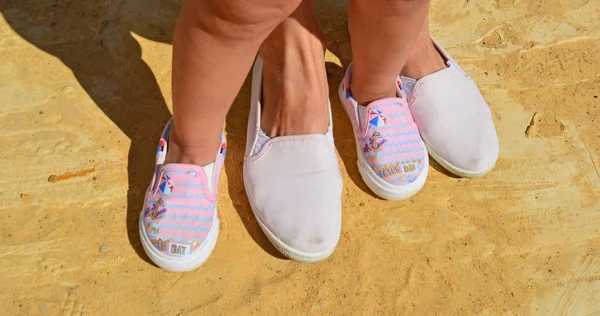 Niños piernas y pies en zapatos zapatillas para adultos . —  Fotos de Stock