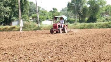 Godhamji veya Ganthiol Idar 'daki Badoli yakınlarındaki tarlasında küçük traktörü süren çiftçi.
