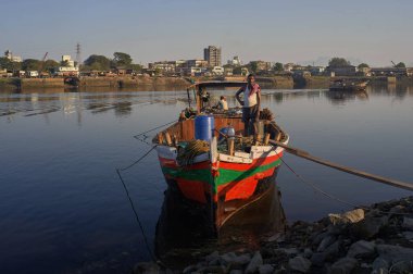25 Kasım 2008 'de Ulhariver Crck Kon Gayan Kalyan Maharashtra Hindistan' da küçük balıkçı teknesi Ancerd 'de duran bir adam.