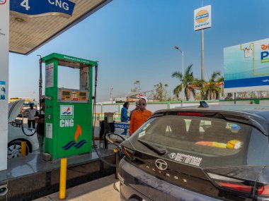 03 08 2024 numaralı CNG Sıkıştırılmış benzin istasyonunda arabası Gujarat India ile duran adam.