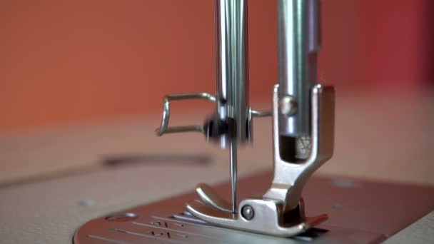 Una aguja de una máquina de coser industrial. Fondo rojo . — Vídeos de Stock