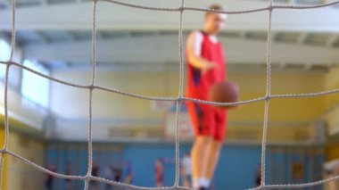 Genç bir basketbolcu spor salonunda antrenman yapıyor..