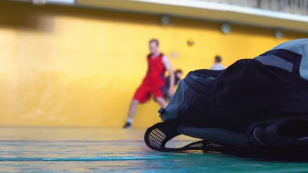 Um jogador de basquete adolescente está treinando na sala de esportes da escola . — Vídeo de Stock