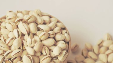 Beyaz ahşap bir masada fıstıklı kase.