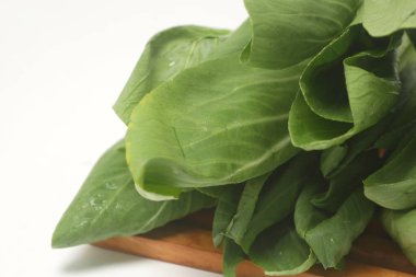 Beyaz arka planda yemek pişirmek için yeşil marul kanton sebzesi